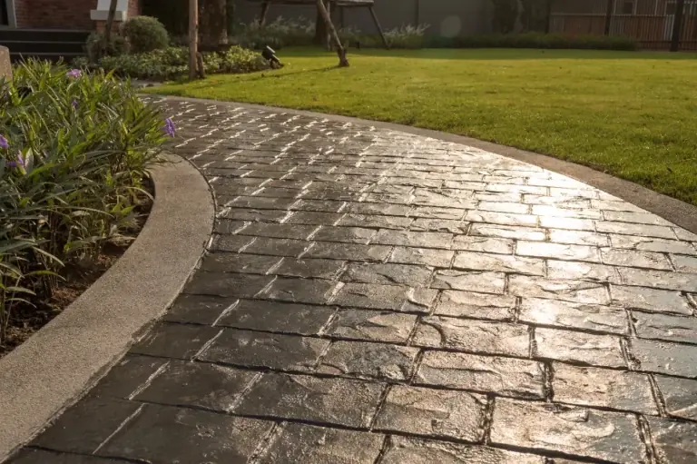 Dark stamped concrete walkway in a slate brick pattern beside a lawn, Spring Hill, FL