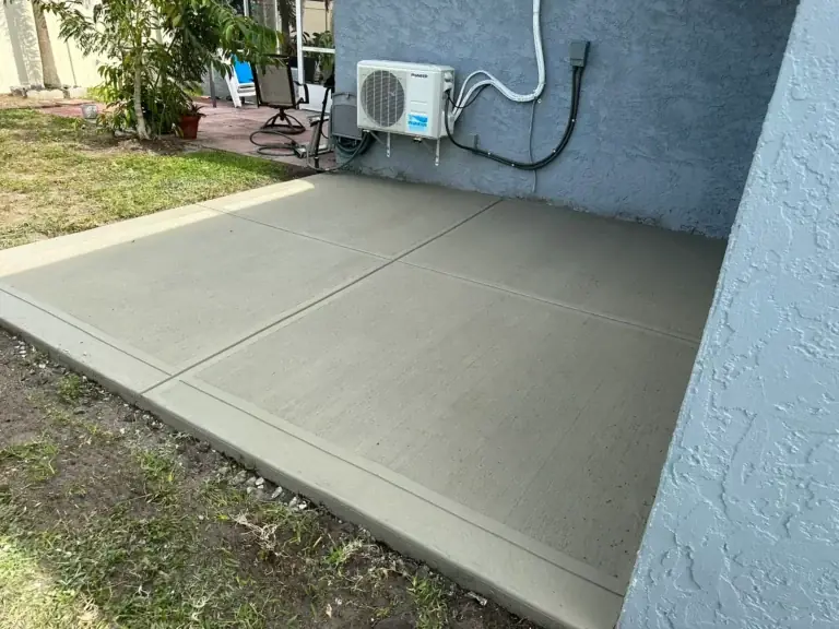 New concrete equipment pad poured beside a house wall and AC unit, South Brooksville, FL
